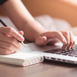 hands on a keyboard and notepad