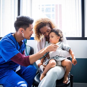 male nurse listening to a young patients heart beat