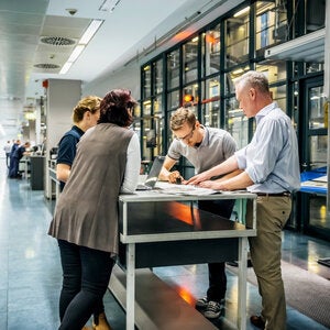 Professionals collaborating around a table, representing teamwork and leadership