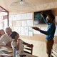 Man doing presentation, using tablet & screen