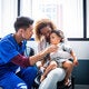 male nurse listening to a young patients heart beat